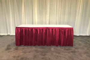 Table with burgundy pleated skirting